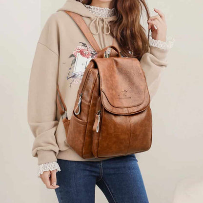 Brun läder ryggsäck för dam – trendig och bekväm, bärs av en kvinna i avslappnad outfit. Perfekt för både stil och funktion.